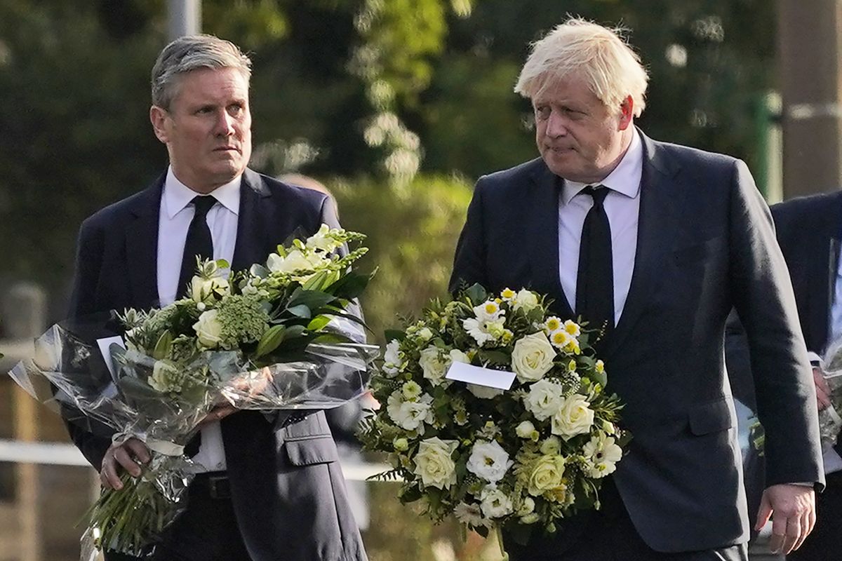 British Prime Minister Boris Johnson, right, and Leader of the Labour Party Keir Starmer carry flowers as they arrive at the scene where a member of Parliament was stabbed Friday, in Leigh-on-Sea, Essex, England, Saturday, Oct. 16, 2021. David Amess, a long-serving member of Parliament was stabbed to death during a meeting with constituents at a church in Leigh-on-Sea on Friday, in what police said was a terrorist incident. A 25-year-old man was arrested in connection with the attack, which united Britain