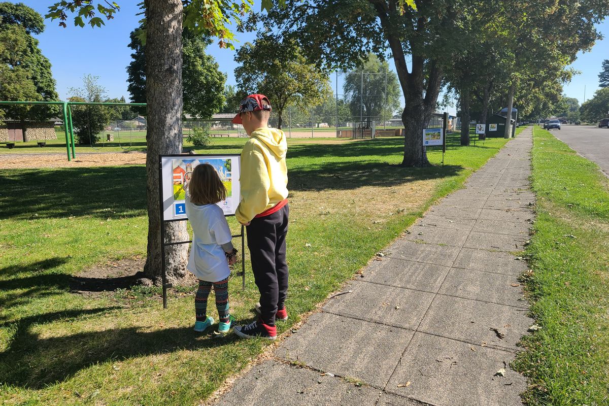 Two children enjoy the Spokane Public Library’s “Read and Walk” activity at Chief Garry Park.  (Spokane Public Library)