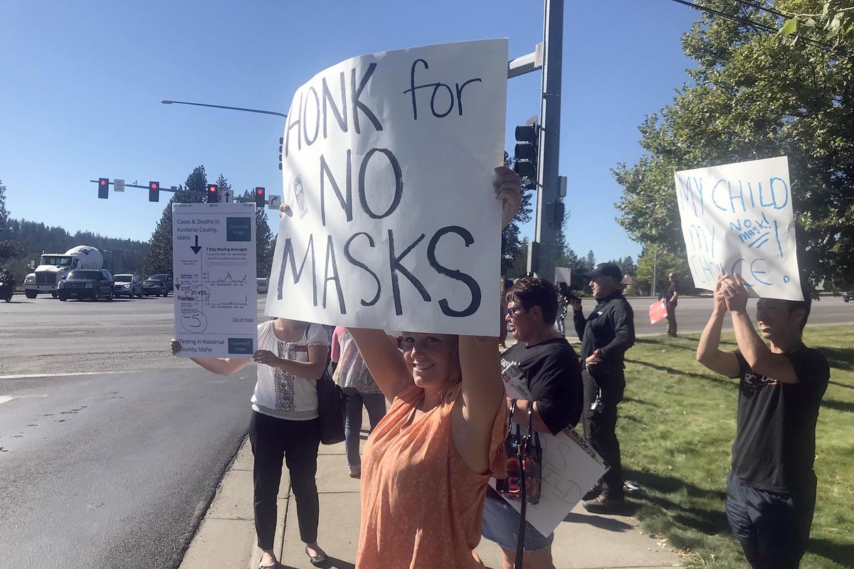Protesters hold signs outside the district office in Coeur d’Alene.  (Kathy Plonka/The Spokesman-Review)