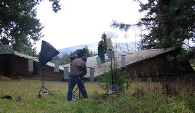 
A production crew member sets up equipment outside the semi-underground home where the TV show 