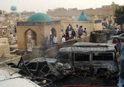 
Iraqis view the wreckage caused by a car bomb which exploded Thursday near the Imam Ali shrine, one of the most sacred sites for Shiite Muslims. At least 12 people were killed and dozens injured. 
 (Associated Press / The Spokesman-Review)