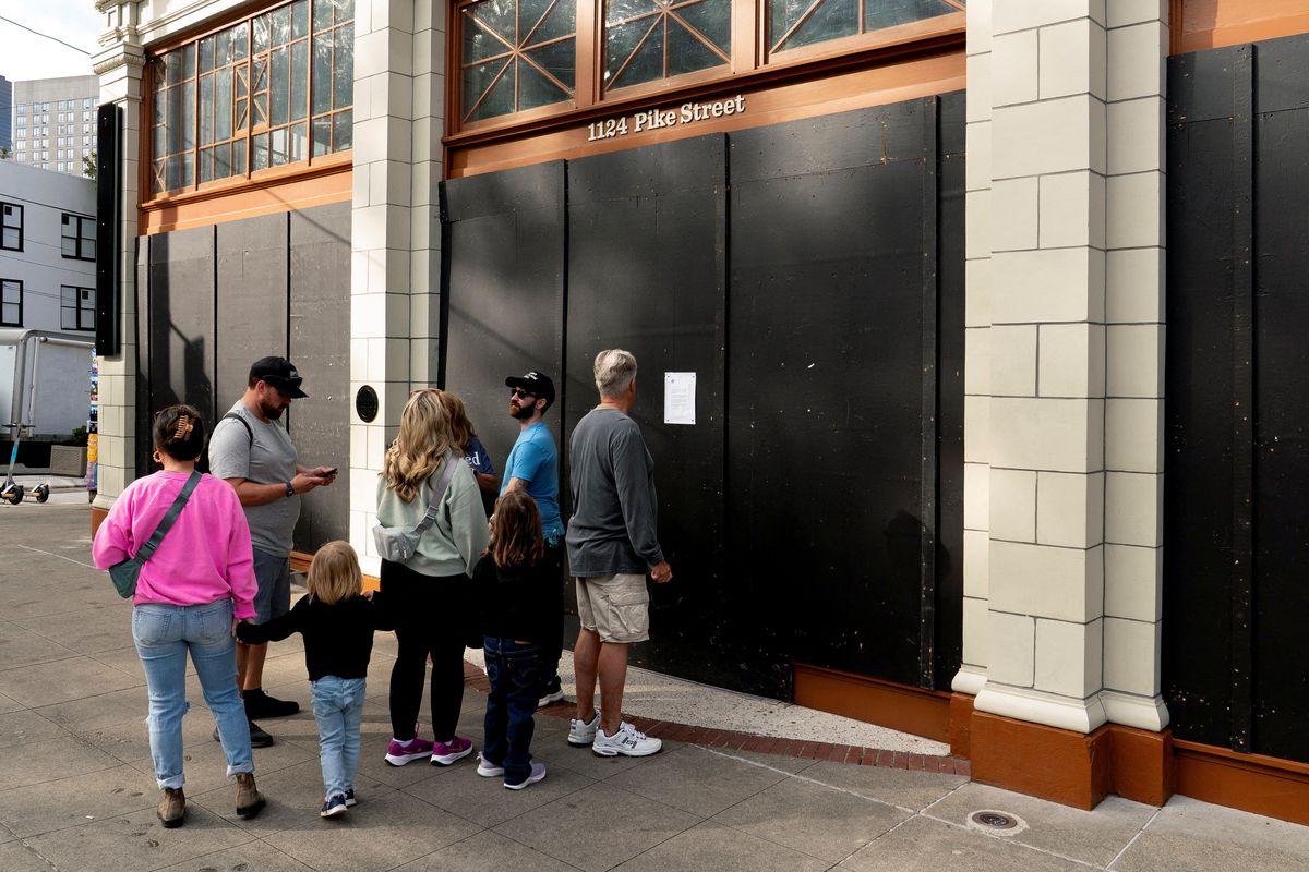 Visitors stand outside the shuttered Capitol Hill Starbucks Reserve Roastery on Thursday in Seattle.  (David Ryder/Reuters)