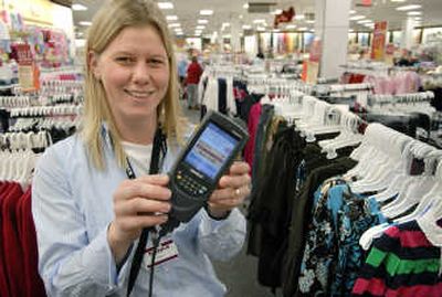 
Angela Bell, at the Kohl's store at NorthTown Mall, holds a  scanner used by employees to set and change an item's price. 
 (Photos by DAN PELLE / The Spokesman-Review)