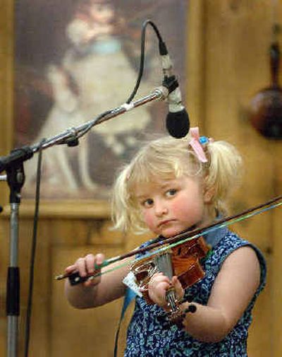 
Macy Morgan, 5, concentrates on her performance on the stage at East Valley High during the Northwest Regional Fiddle Contest Saturday morning. 
 (Jesse Tinsley / The Spokesman-Review)