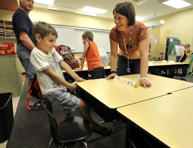 Freeman Elementary School first-grade teacher Chris Cochrane helps Andrew Kopytin select his classroom seat during an open house Monday at the newly remodeled school. Cochrane has taught first grade for 25 years, including 10 at Freeman. (Dan Pelle)