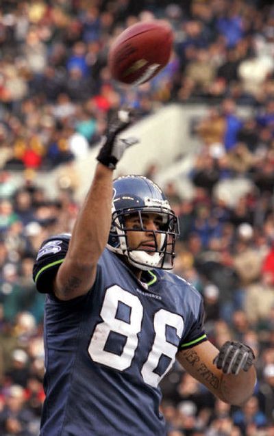 
Seattle's Jerramy Stevens tosses the football into the stands after a touchdown catch earlier this season.
 (Associated Press / The Spokesman-Review)