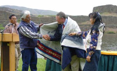 
Bob Lohn, regional administrator of National Oceanic and Atmospheric Administration Fisheries, is presented with a blanket by Rafael Queahpama and Aurolyn Stwyer, as Warm Springs Chairman Ron Suppah, far left, looks on in Dallesport, Wash., Friday. Associated Press
 (Associated Press / The Spokesman-Review)