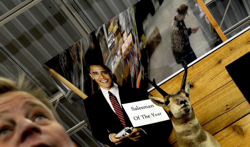Nathaniel Pulliam of Black Sheep sporting goods in Coeur d'Alene works the gun counter on Wednesday, January 14, 2009. The owners of Black Sheep put up the cutout of Barack Obama after the election. KATHY PLONKA The Spokesman-Review (Kathy Plonka / The Spokesman-Review)