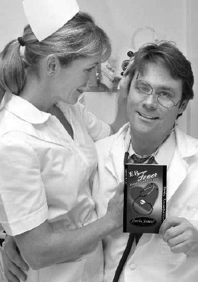 
Books By You founder Mike Pocock, right, playfully poses in hospital garb with ER Fever author Wendy Pickett, holding a copy of her book in Hood River, Ore. Books By You says it sells thousands of personalized romance novels each year with titles such as 