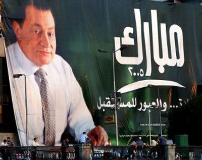 
Egyptians sit under a giant poster promoting President Hosni Mubarak, leader of the ruling National Democratic party, in Cairo, Egypt, Tuesday.
 (Associated Press / The Spokesman-Review)