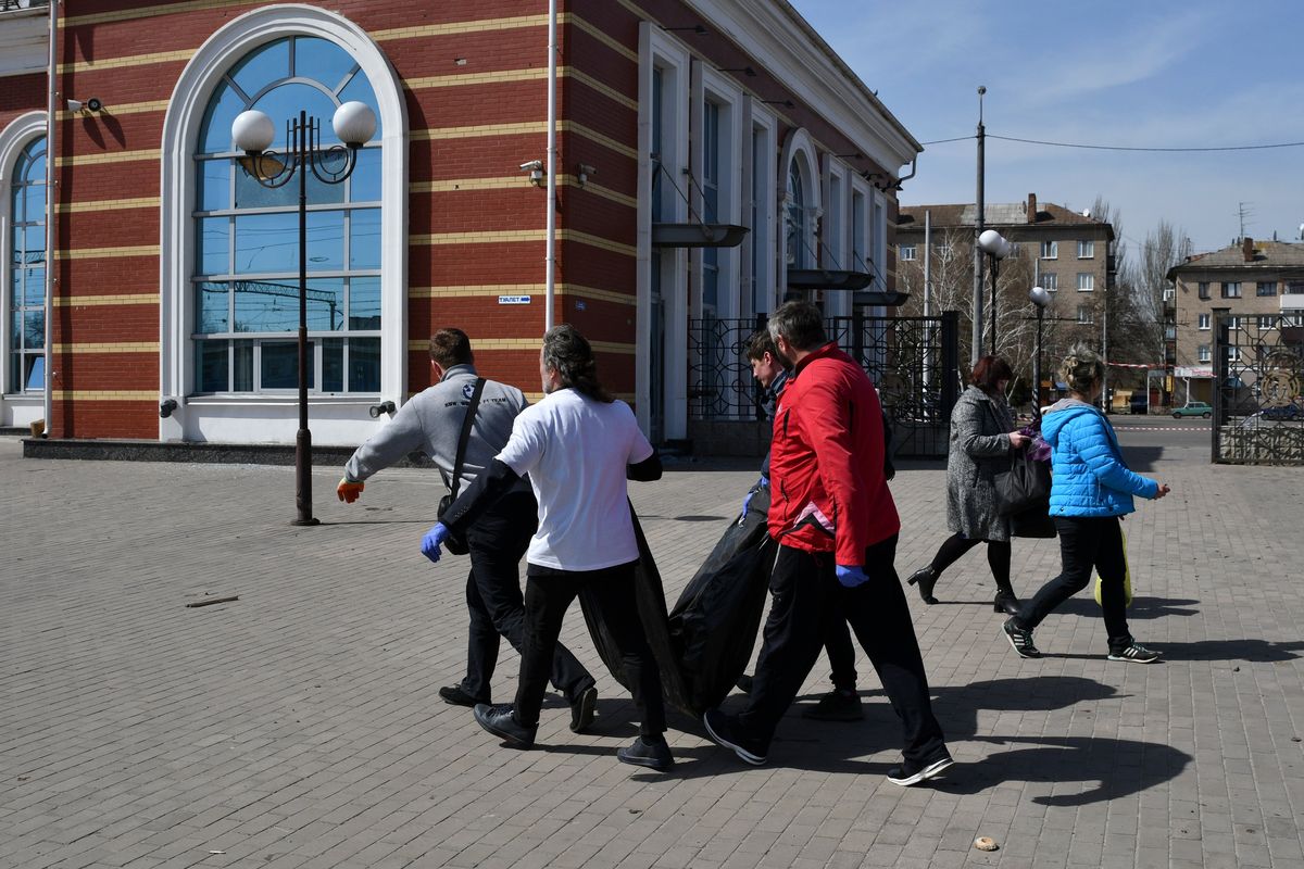 Men carry a killed body after Russian shelling at the railway station in Kramatorsk, Ukraine, Friday, April 8, 2022. Hours after warning that Ukraine