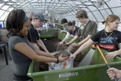 Spokane Valley High School horticulture students AOleon  Allen, left,  and Amanda Lipe, right, mix soil to be used for potting geraniums  that will be sold at the school’s plant sale in May. The school has been named one of Washington’s top 10 alternative high schools.  (J. BART RAYNIAK / The Spokesman-Review)