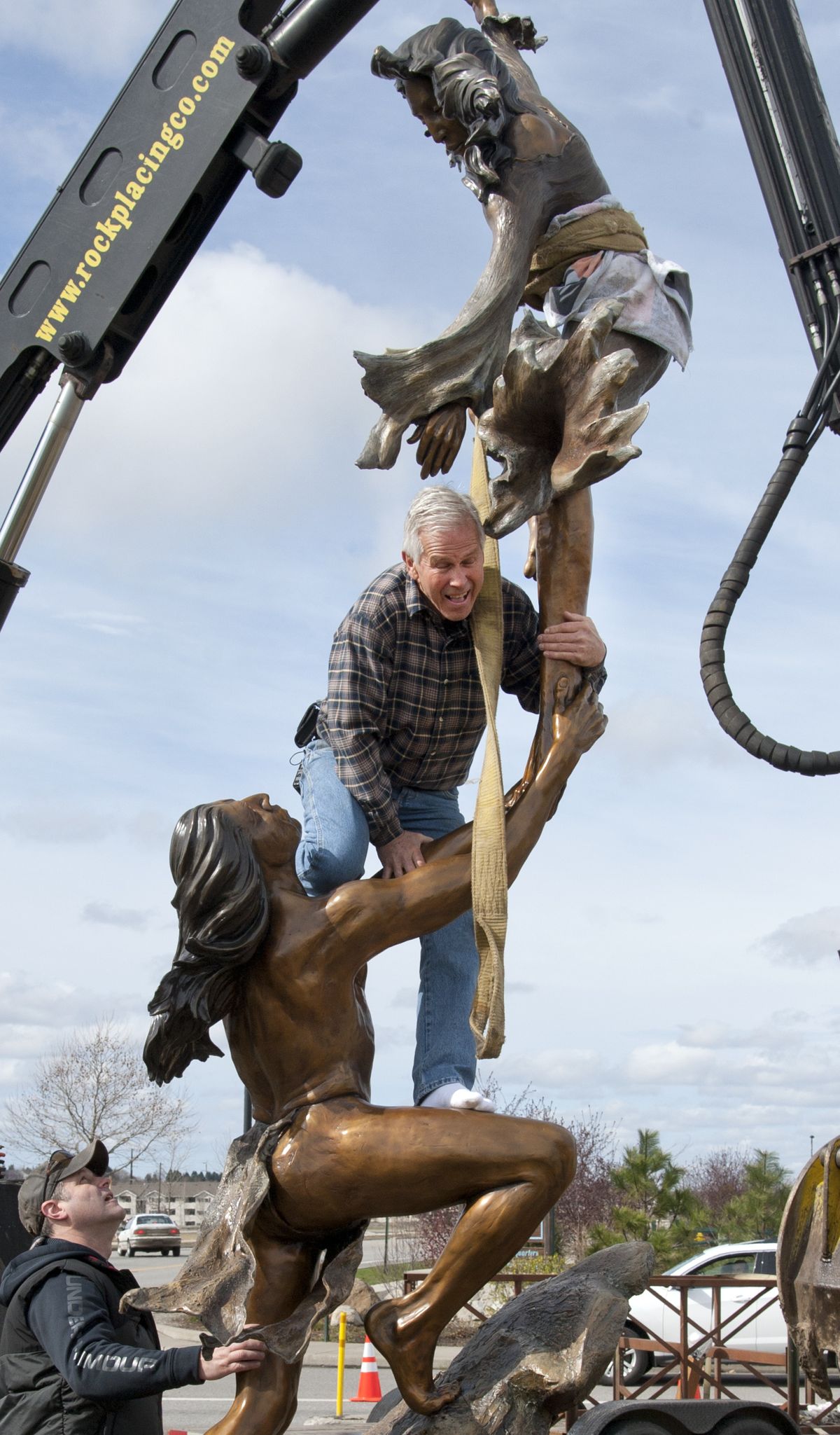 Artist Jerry McKellar, right, gets help from Joe Kronenberg installing his “Dance of Sun & Moon” sculpture Thursday. See a Big Picture Gallery at www.spokesman.com. (Dan Pelle)