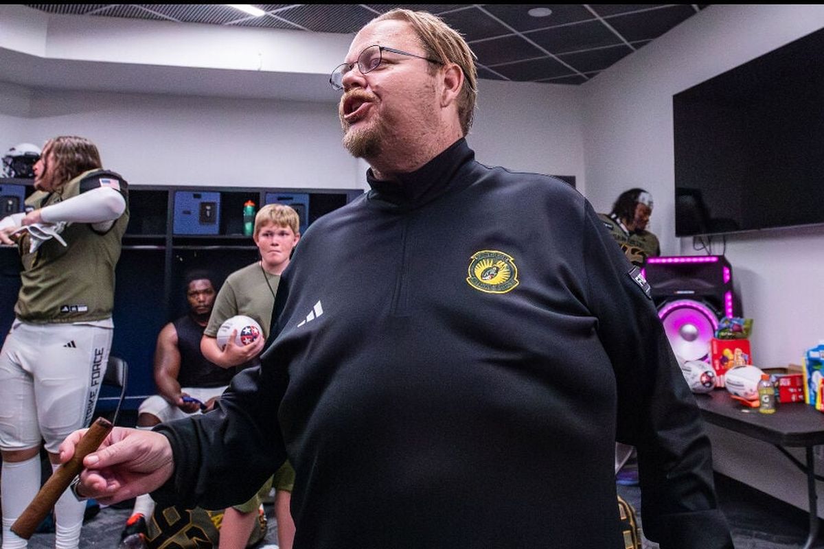 Adam Shackleford stands in front of his players, holding a cigar to his mouth following a Strike Force victory. (Courtesy of Adam Shackleford)