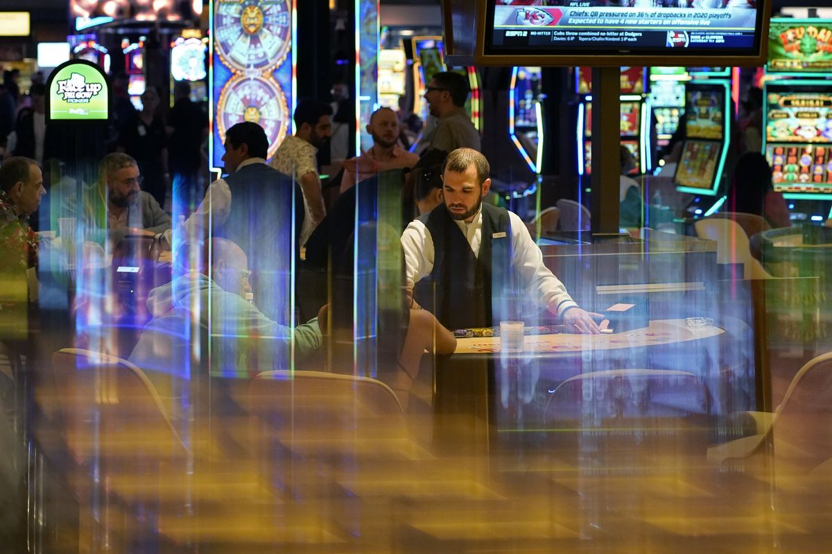 In this June 24, 2021, photo, a dealer distributes cards to gamblers during the opening night of Resorts World Las Vegas in Las Vegas. Las Vegas fully reopened and lifted restrictions on most businesses June 1, though many casino-resorts had already returned to 100% capacity before that with approval from state regulators. Visitor numbers, while not at their pre-pandemic highs, have grown by double digits four months in a row. But this progress is threatened as Nevada this week saw the highest rate of new COVID-19 cases in the country.  (John Locher)