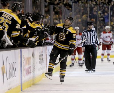 Bruins center Patrice Bergeron is congratulated by teammates after scoring the first of his four goals against the Carolina Hurricanes on Saturday in Boston. (Mary Schwalm / Associated Press)
