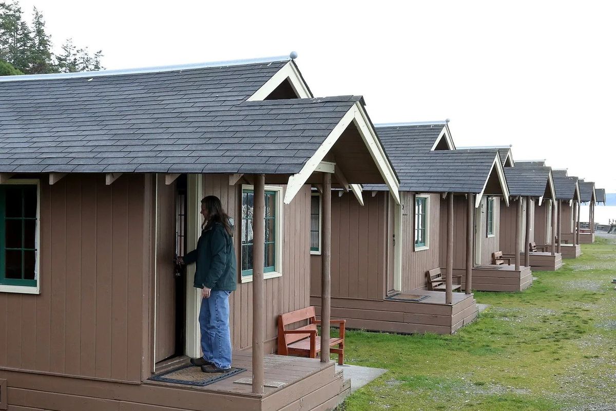 Deb Bell, a Cama Beach Historic State Park customer service manager, unlocks a beachside cabin in January 2019.  (Greg Gilbert / The Seattle Times)