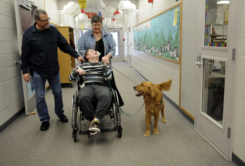 Dylan Long takes Adams the Therapy Dog for a walk down the Barker High School hallway with para-pro Ron Polley, and Comprehensive Medical Intervention teacher, Lynn Kovacich, during school Tues., March 8, 2011. Lynn has been using the male Golden Retriever in her classroom for the past two years. (J. Bart Rayniak)