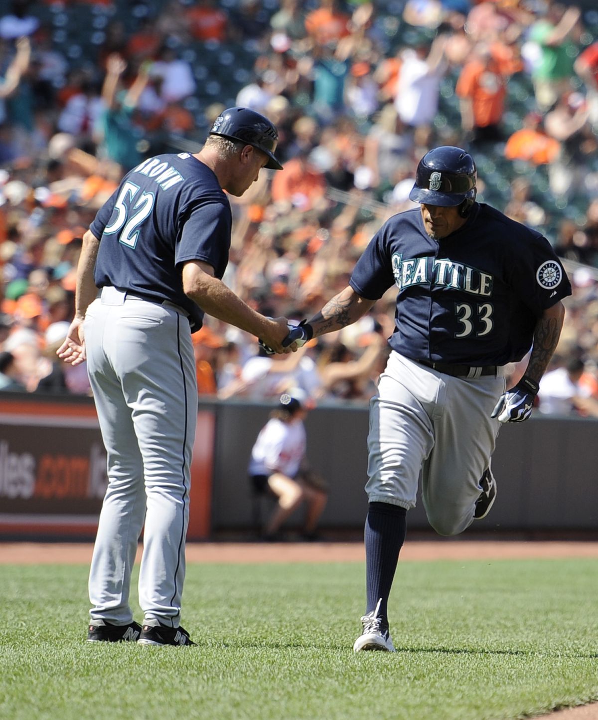 M’s Henry Blanco is greeted by third-base coach Daren Brown after his go-ahead two-run home run on Sunday. (Associated Press)