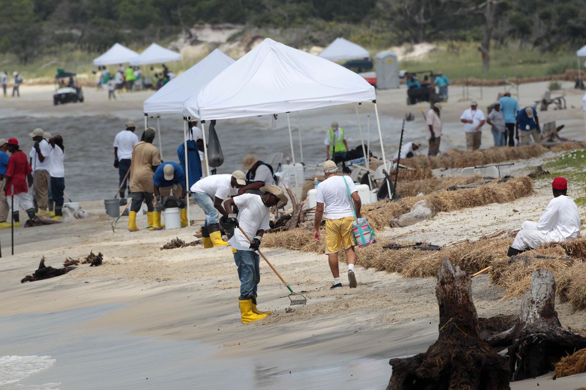 Cleanup workers outnumbered tourists  on the Dauphin Island, Ala., beach Saturday. Oil from the Deepwater Horizon incident is expected to continue to come ashore over the Fourth of July weekend.  (Associated Press)