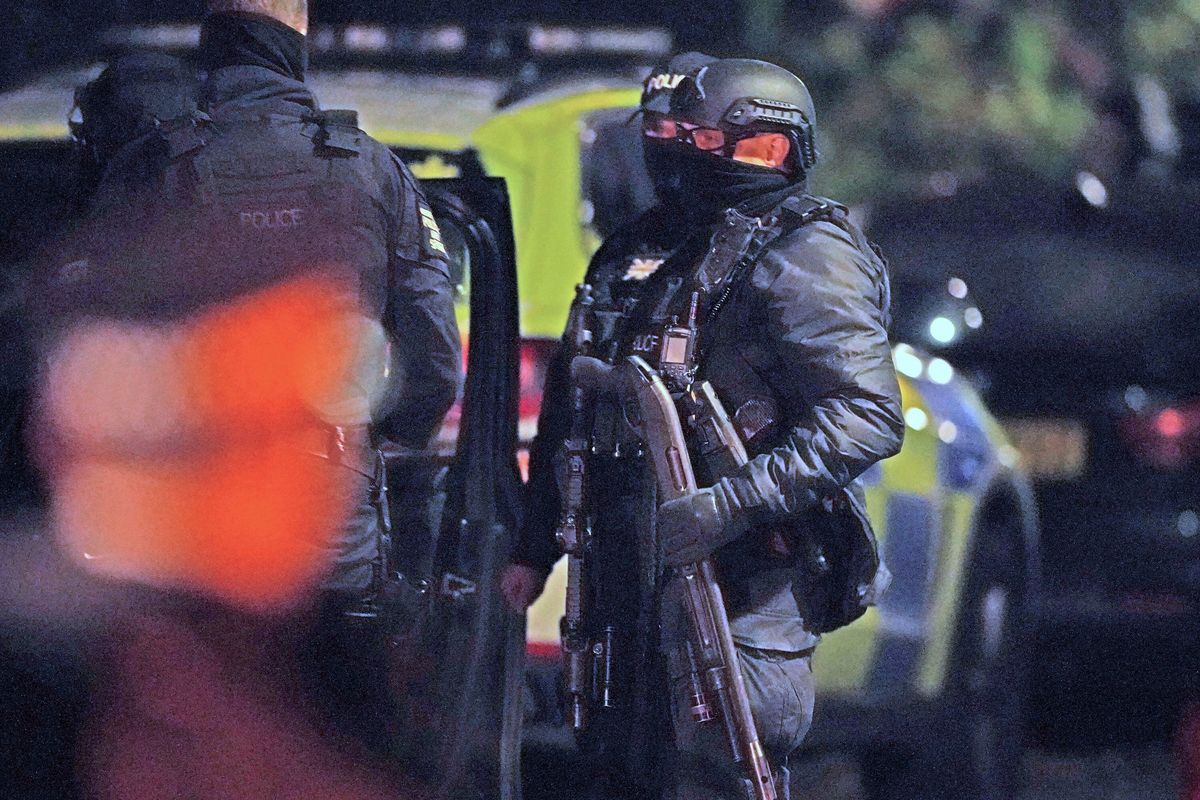 An armed police officer holds a breaching shotgun, used to blast the hinges off a door, at an address in Rutland Avenue in Sefton Park, after an explosion at the Liverpool Women