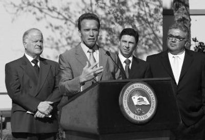 
California Gov. Arnold Schwarzenegger, shown with state lawmakers,  answers questions Thursday before signing a bill to  move California's presidential primary election  to Feb. 5. 
 (Associated Press / The Spokesman-Review)