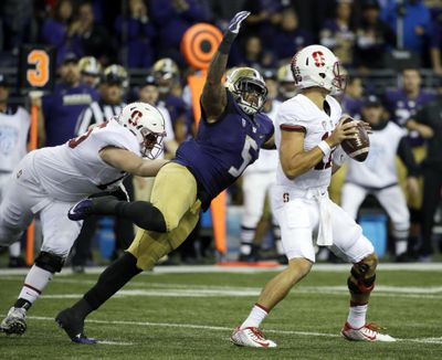 Washington’s Joe Mathis tackles Stanford quarterback Ryan Burns in UW’s win over the Cardinal on Sept. 30. Mathis had two sacks in the game but has been lost for the season with a foot injury. (Ted S. Warren / Associated Press)
