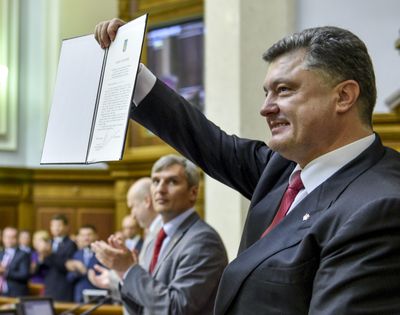 Ukrainian President Petro Poroshenko shows the Ukraine-EU Association Agreement to lawmakers after its signing in parliament in Kiev, Ukraine, on Tuesday. (Associated Press)