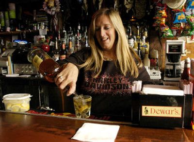 
Bartender Grace Maurillo pours a drink at Morris's Grill in Skaneateles, N.Y., Thursday. People tend to unwittingly pour more alcohol into short, wide glasses compared with tall, skinny ones, according to a new study. 
 (Associated Press / The Spokesman-Review)