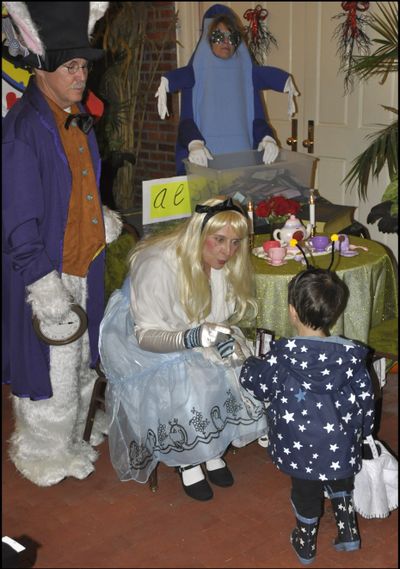 OLYMPIA -- Gov. Chris Gregoire, dressed as Alice in Wonderland, with husband Mike dressed as the White Rabbit, greets 2 1/2 year old Jack Kesler of Olympia Halloween night at the governor's mansion. (Jim Camden)