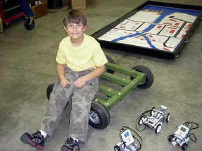 
Nicolia Ripplinger, 9, sits in his father's shop on a base of what will become a robot. Beside him are small robots that he has learned to program.Jennifer LaRue
 (Jennifer LaRue / The Spokesman-Review)