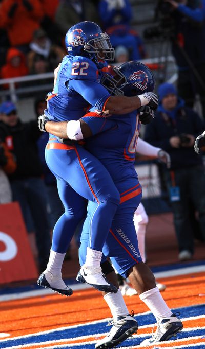 Doug Martin (22) and Thomas Byrd celebrate one of Martin’s four TDs. (Associated Press)