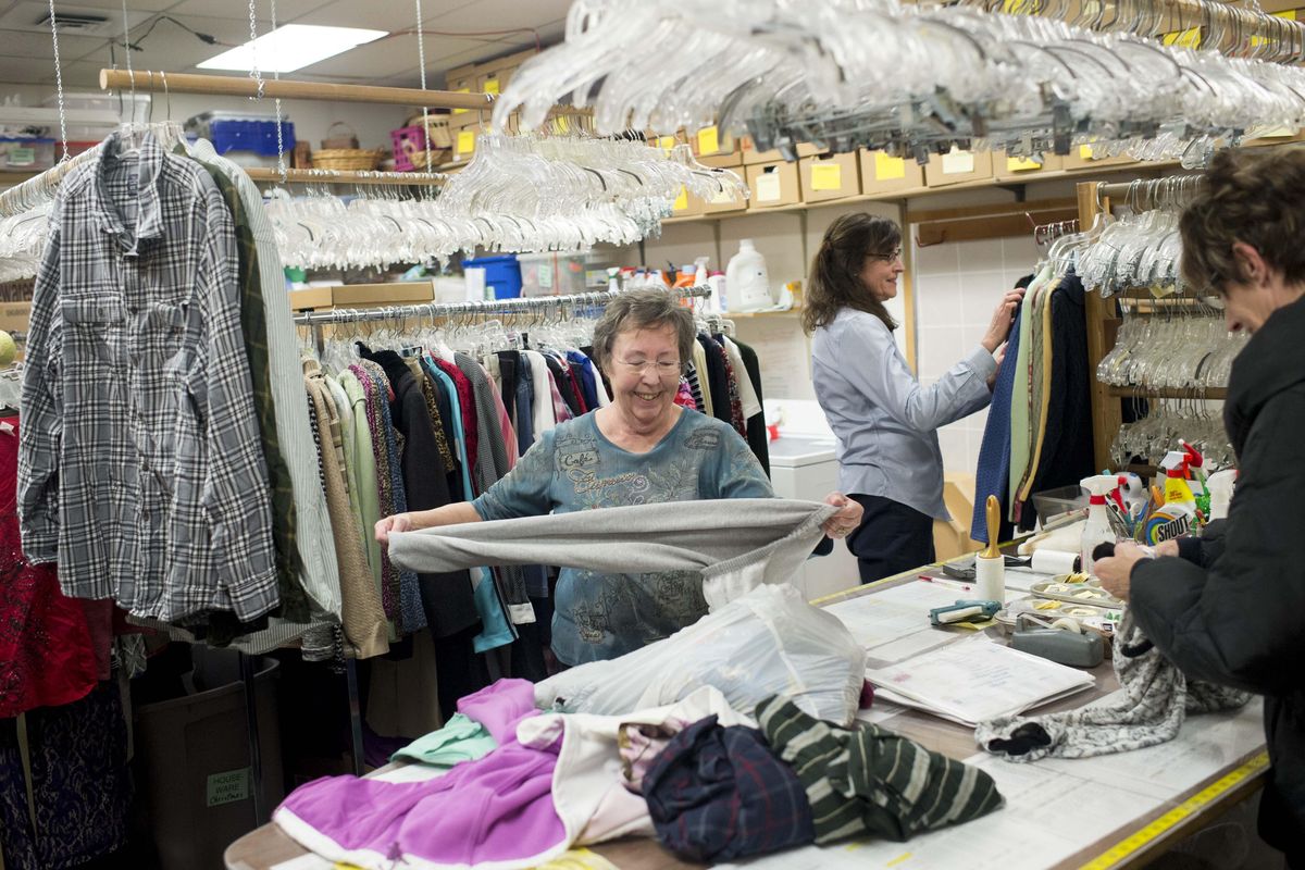JoAnne Henault, left, works with volunteers Robin Johnson, Karen Liere, right, and (not pictured) Barbara Brown and Jeff Hunter, to fold and hang recently donated garments on Friday, Dec. 30, 2016, at the American Cancer Society Discovery Shop on West Garland Avenue in Spokane. (Tyler Tjomsland / The Spokesman-Review)