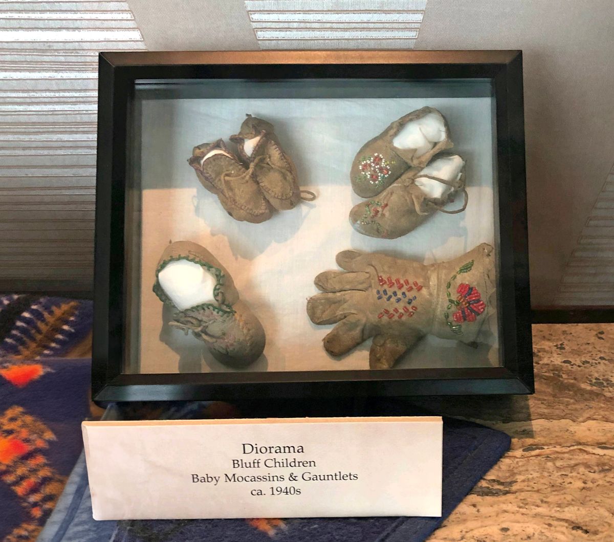 Five moccasins and a beaded leather glove in this shadow box were stolen from a display case at Northern Quest Resort & Casino in the early morning Oct. 30, 2020. The Kalispel Tribe is offering $25,000 for information that leads to their safe return.  (Courtesy of the Kalispel Tribe)