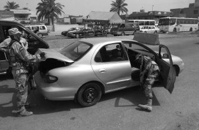 
Iraqi soldiers search a car at a checkpoint on a major road in the Sadr City neighborhood in Baghdad on Wednesday. Iraqi and U.S. forces conducted raids in the neighborhood in the early morning, apparently searching for five British men abducted  Tuesday. 
 (Associated Press / The Spokesman-Review)