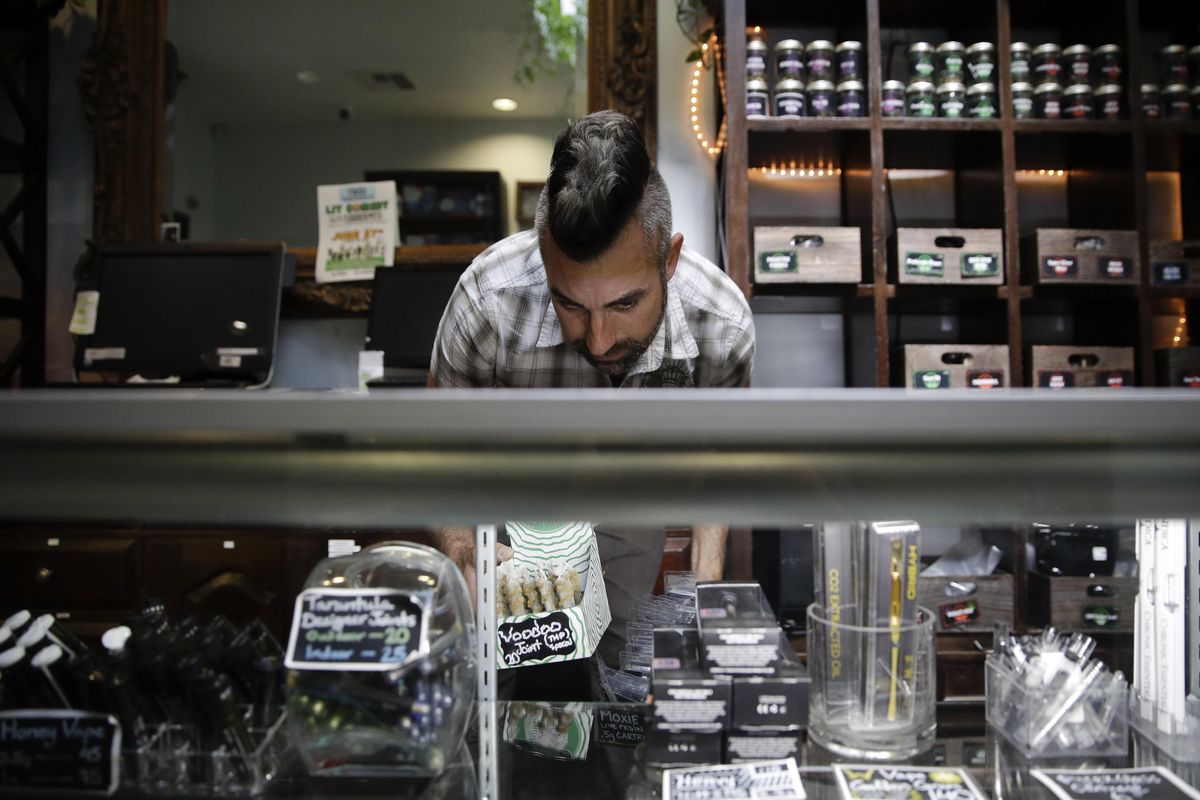 In this June 27, 2017,  photo, Jerred Kiloh, owner of the Higher Path medical marijuana dispensary, stocks shelves with with cannabis products in Los Angeles. (Jae C. Hong / Associated Press)
