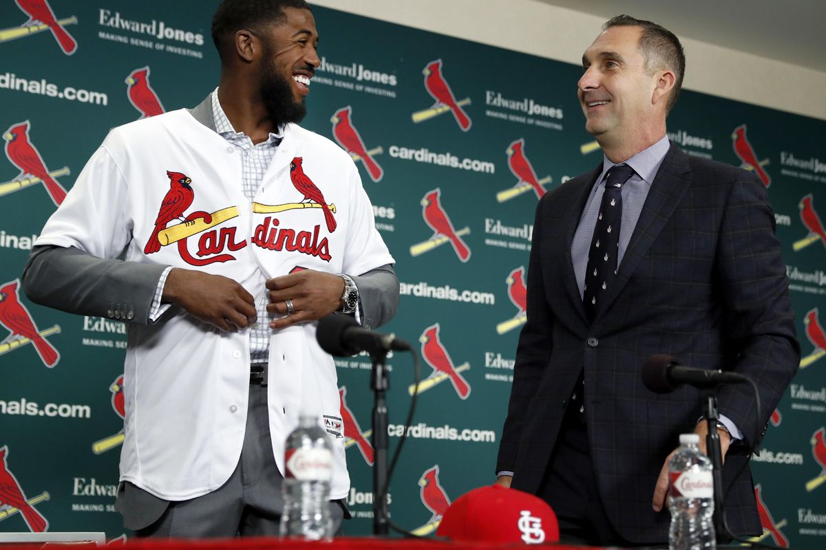 St. Louis Cardinals general manager John Mozeliak, right, watches as Dexter Fowler puts a Cardinals jersey during a baseball news conference announcing the signing of the free agent center fielder Friday, Dec. 9, 2016, in St. Louis. (Jeff Roberson / Associated Press)