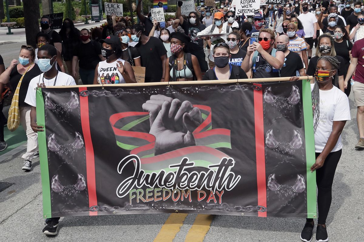 In this June 19, 2020 photo, demonstrators march through downtown Orlando, Fla., during a Juneteenth event. Congress and President Joe Biden acted with unusual swiftness Thursday, June 17, 2021, in approving Juneteenth as a national holiday. That sent many states scrambling to clarify their policies on the celebration of slavery’s end. This year alone, Juneteenth bills hit roadblocks in Florida, Maryland, Ohio and South Dakota.  (John Raoux)