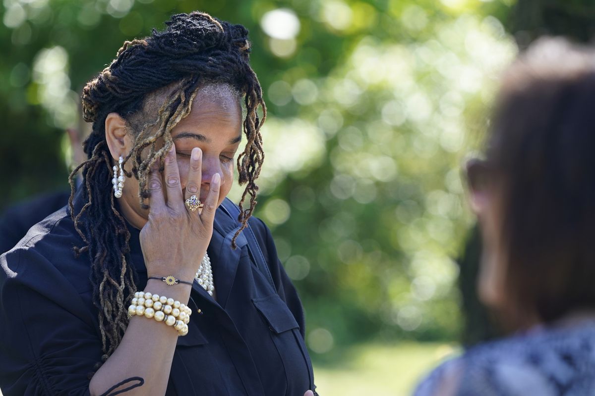 Edwina Frances Martin, Staten Island’s public administrator of estates, wipes away tears as she says a few words during a burial for four people at a cemetery in the Staten Island borough of New York, Thursday, June 17, 2021. The deceased died during the coronavirus pandemic and were being stored at a temporary morgue in Brooklyn. The facility is out of sight and mind for many as the city celebrates its pandemic progress but stands as a reminder of the loss, upheaval and wrenching choices the virus inflicted in one of its deadliest U.S. hotspots.  (Seth Wenig)