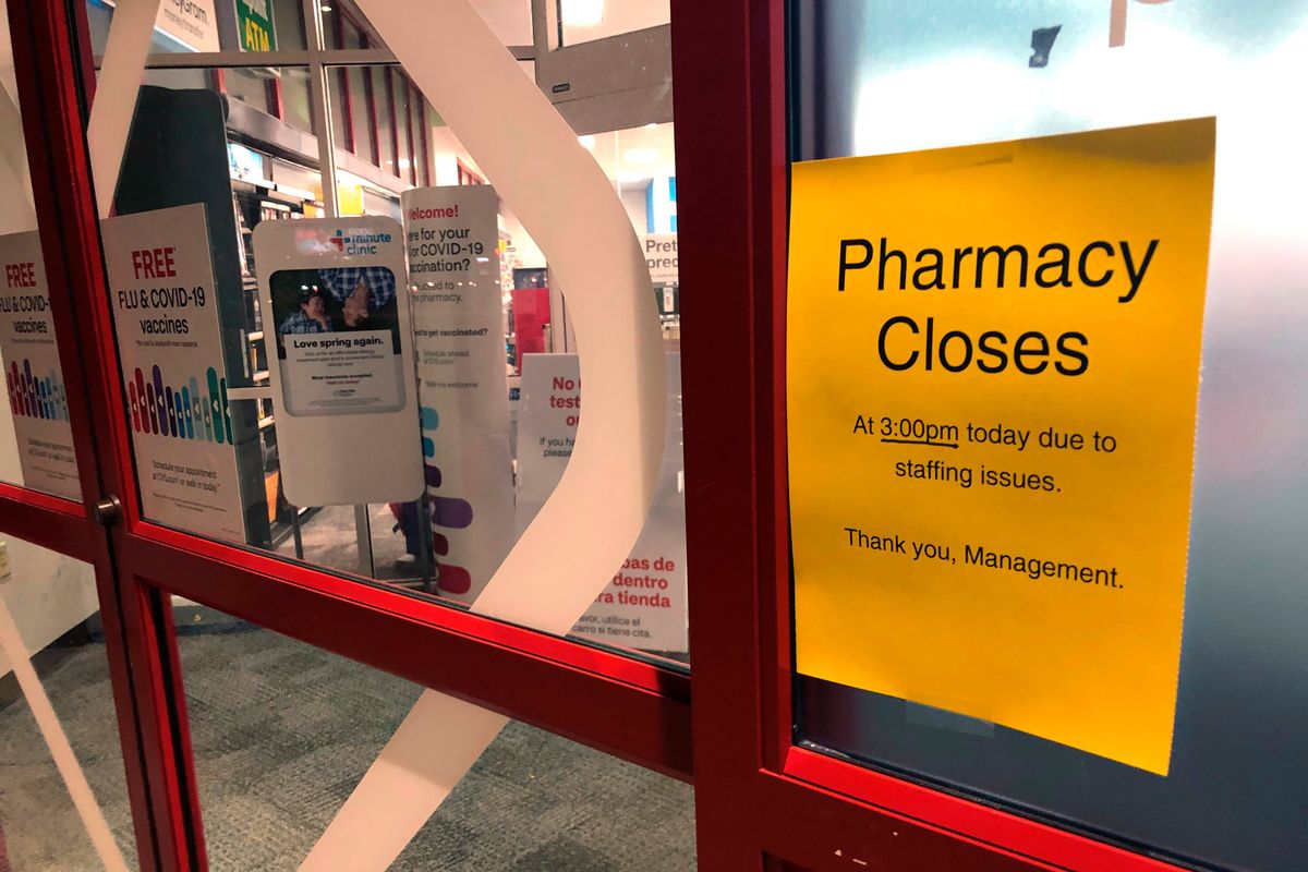 A sign is posted outside a CVS pharmacy on Thursday, Dec. 2, 2021 in Indianapolis. A rush of vaccine-seeking customers and staff shortages are squeezing drugstores around the country. That has led to frazzled workers and even temporary pharmacy closures.  (Tom Murphy)