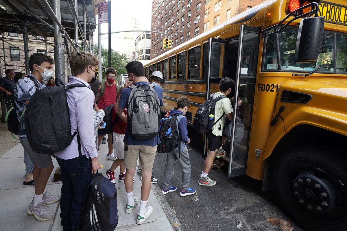 In this Sept. 13, 2021 photo, students board a school bus on New York