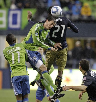 Seattle Sounders’ Brad Evans, center, heads the ball in front of Steve Zakuani and Philadelphia’s David Myrie (21).  (Associated Press)