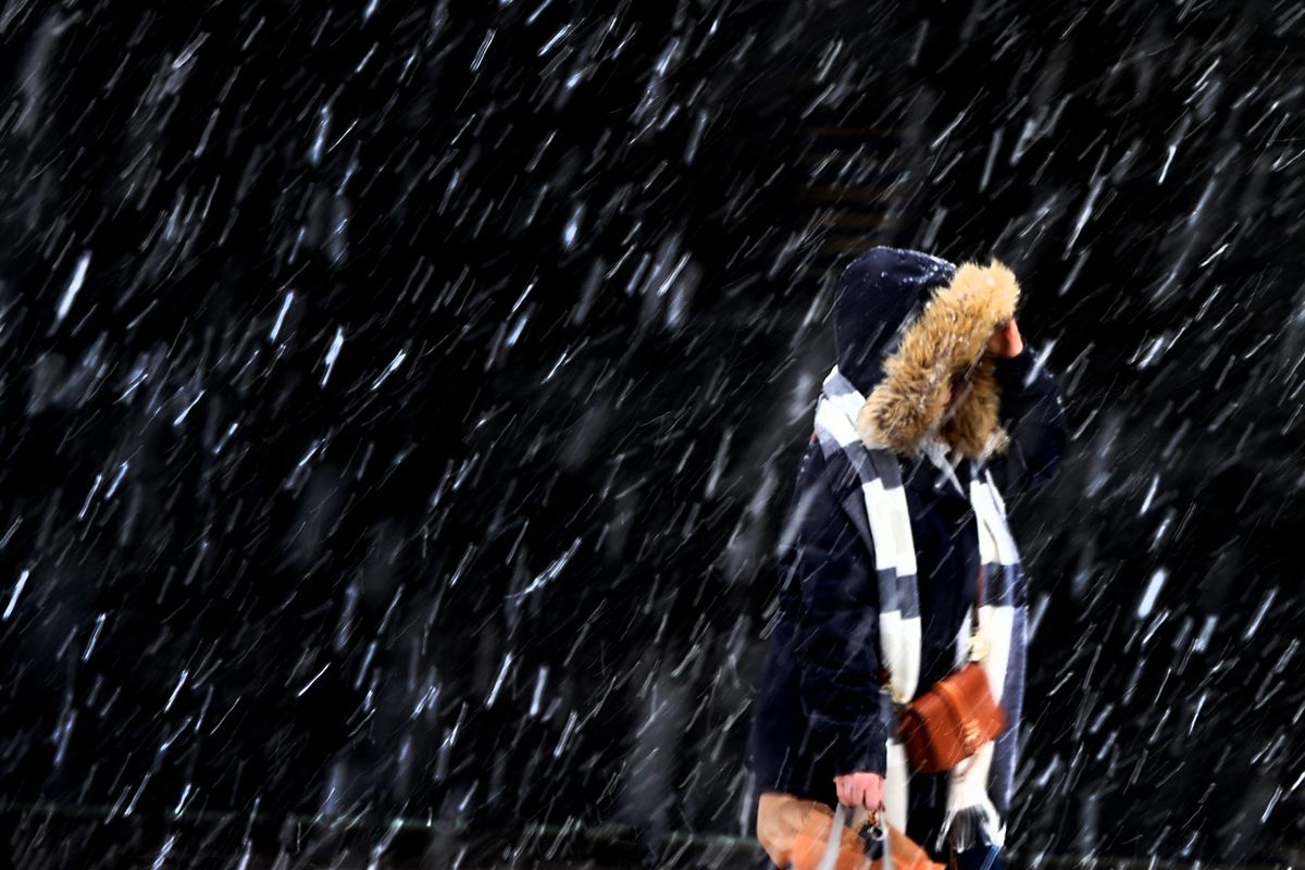 A pedestrian heads south on Post Street in a snowstorm on Friday, Dec. 9, 2016, in downtown Spokane, Wash. The weather forecast shows periods of snow falling through Monday. (Colin Mulvany / The Spokesman-Review)