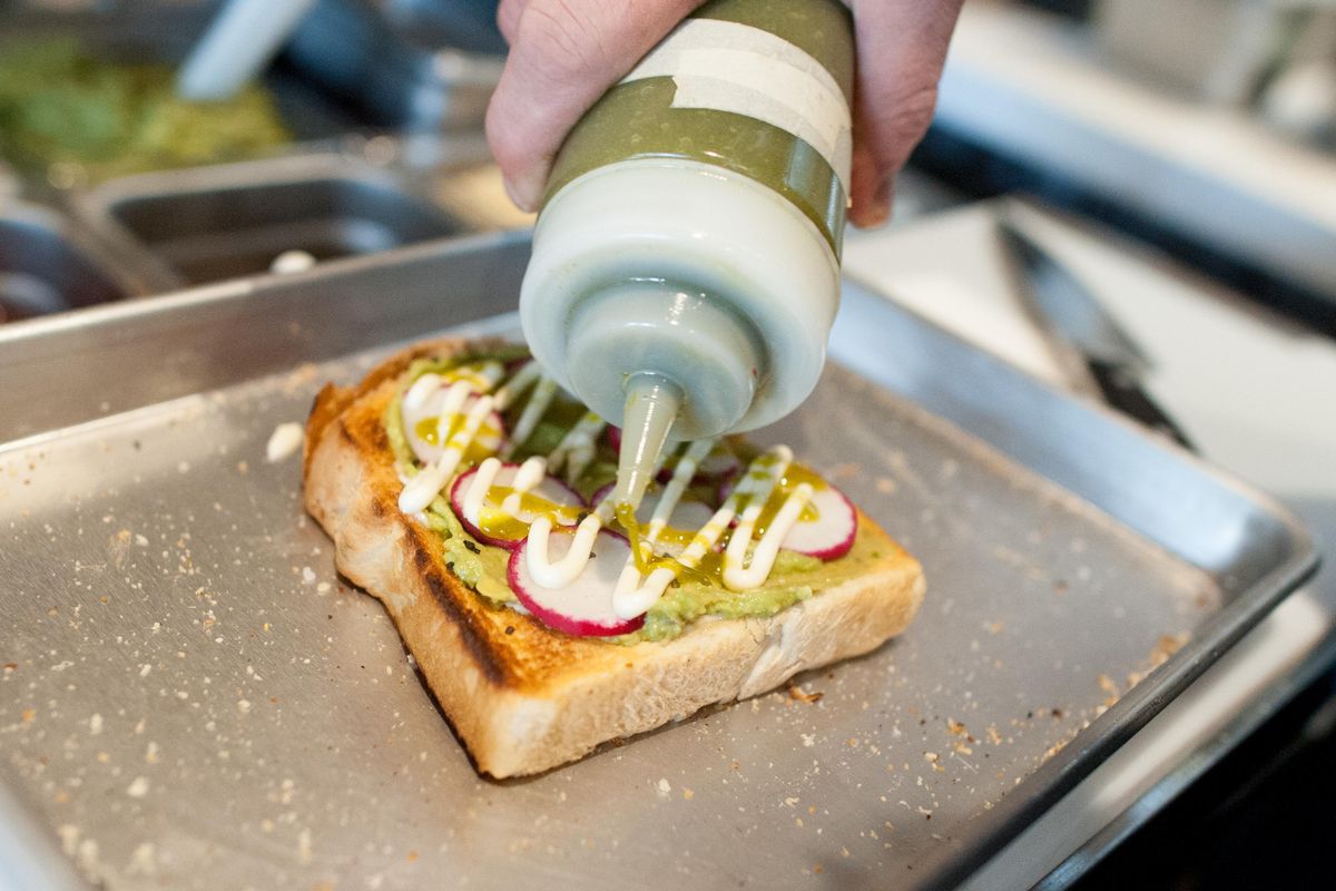 Andrew Larson, chef at the new Indaba on West Riverside Avenue, decorates fancy toast, a menu staple at the coffee shop’s latest location. (Tyler Tjomsland / The Spokesman-Review)