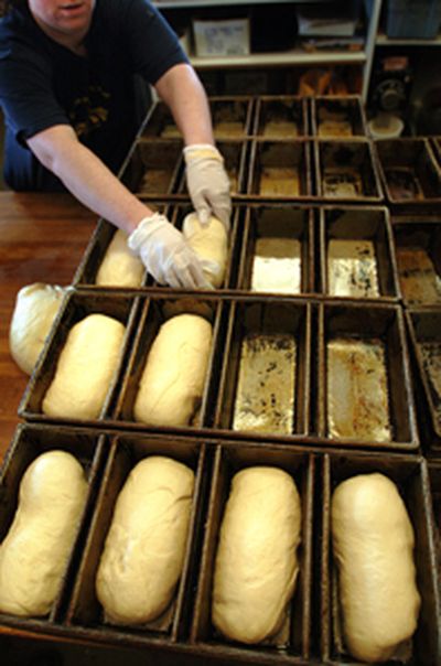
Fresh dough is kneaded and shaped into loaves of bread then placed into rows of bread tins at the Great Harvest Bread Co.
 (The Spokesman-Review)