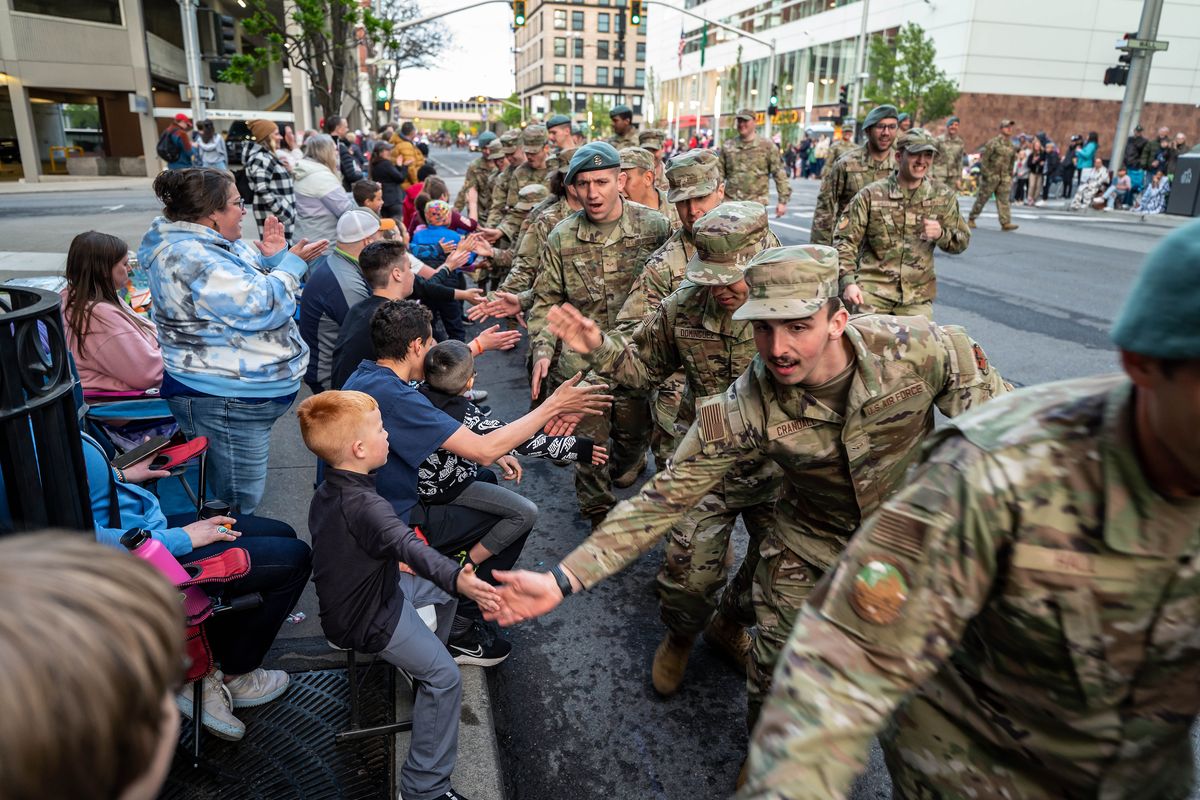 Airmen from Fairchild Air Force Base slap hands along the parade route on First Avenue on Saturday during the Spokane Lilac Festival’s Armed Forces Torchlight Parade in downtown Spokane.  (COLIN MULVANY/THE SPOKESMAN-REVIEW)
