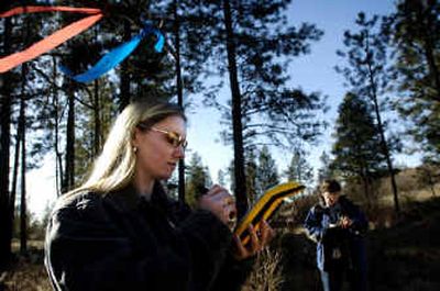 
Natural resources student Jill Peterson uses a global positioning system receiver while her Spokane Community College instructor, Monica Spicker, records data on a clipboard Wednesday. Spicker's students came to a wooded area south of Spokane to practice plotting the points for a mapping exercise. 
 (Holly Pickett / The Spokesman-Review)