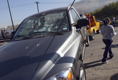 A bullet-riddled pickup truck is towed after unknown gunmen opened fire on it, killing a man and a woman, in Tijuana, Mexico, Tuesday.  (Associated Press / The Spokesman-Review)
