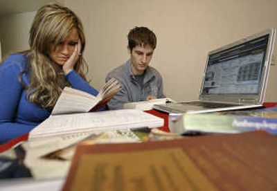 
WSU student Abbey Holton studies with her fiancé, Paul Vinuelas, using books she rented through Chegg, an online service, in her apartment in Pullman last week. 
 (Tyler Tjomsland / The Spokesman-Review)