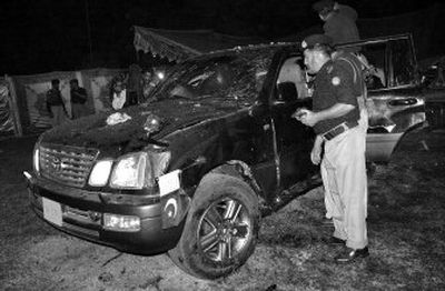 
 Police officers examine the damaged vehicle of Pakistan's interior minister, Aftab Khan Sherpao, at the site of suicide bombing Saturday in Charsadda. 
 (Associated Press / The Spokesman-Review)
